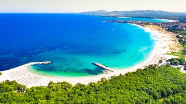 Photo of Saint Anastasia Island in Burgas bay, Black Sea, Bulgaria. Lighthouse tower and old wooden buildings on rocky coast.