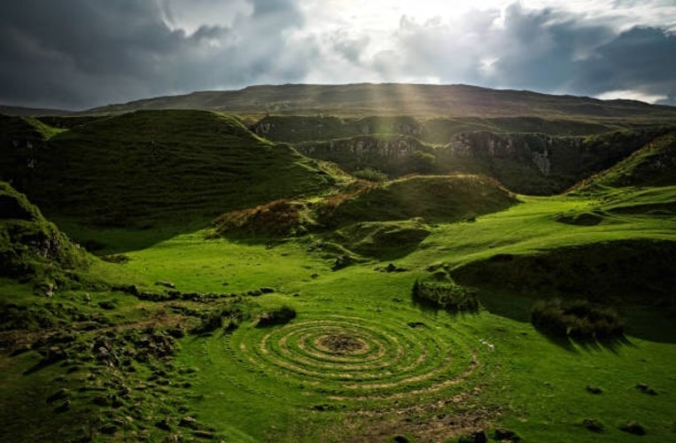 A magical view of the Fairy Glen on the Isle of Skye, Scotland, featuring rolling green hills and unique rock formations.jpg