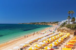 Photo of wide sandy beach in white city of Albufeira, Algarve, Portugal.