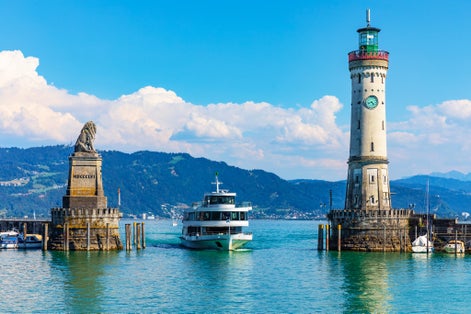 Photo of Scenic summer view of the lighthouse and lion statue in the harbor of the Old Town of Lindau on Bodensee or Constance lake in Bavaria, Germany .