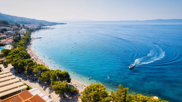 Photo of panorama and landscape of Makarska resort and its harbour with boats and blue sea water, Croatia.