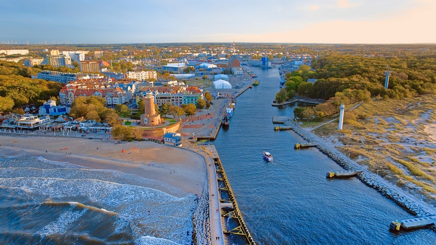 Port and lighthouse in Kołobrzeg, Poland. Photo taken with a drone at the beginning of autumn. The rippling, blue Baltic Sea.