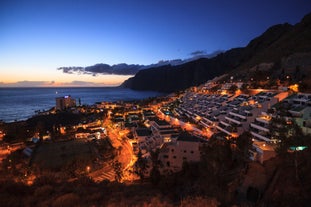 photo of aerial shot of Costa Adeje area, South Tenerife, Spain. Captured at golden hour, warm and vivid sunset colors. Luxury hotels, villas and restaurants behind the beach.