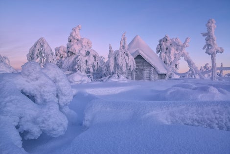 Photo of house in winter forest, Luosto, Finland.