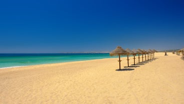 Photo of wide sandy beach in white city of Albufeira, Algarve, Portugal.