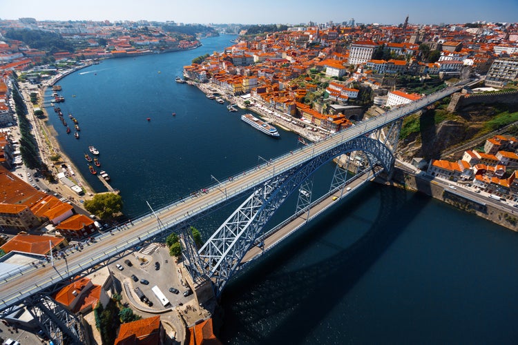 Photo of aerial view of the metal arch bridge (Dom Luise bridge) between the city of Porto and the city of Vila Nova de Gaia at sunny day, Portugal.