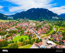 photo of Elevated, scenic view of the town of Bischofswiesen, Bavaria, Germany. The Watzmann Mountain, part of the Bavarian Alps rises into a majestic skyline. A green, spring landscape set in the valley.