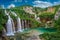 Photo of beautiful waterfalls of Plitvice Lakes (Plitvička jezera) in Plitvice National Park on a bright summer day with blue sky and clouds, municipality of Korenica, Croatia.