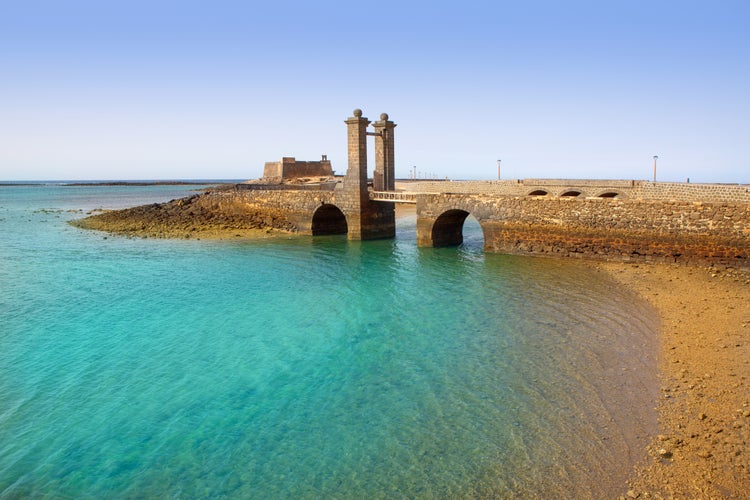 Photo of Arrecife Lanzarote Castillo San Gabriel castle and Puente de las Bolas bridge with beautiful beach view.