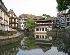 Photo of traditional half-timbered houses on picturesque canals in La Petite France in the medieval fairytale town of Strasbourg, France.