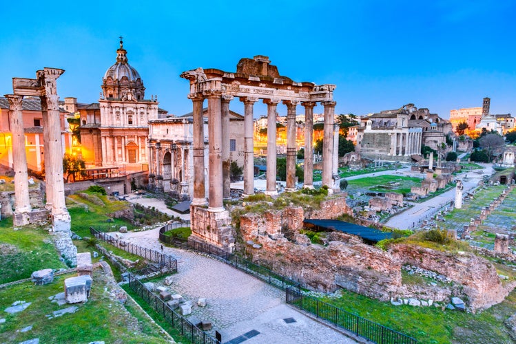 Rome, Italy. Stunning twilight view of Forum ancient ruins, seen from Capitoline hill with Colosseum in background.