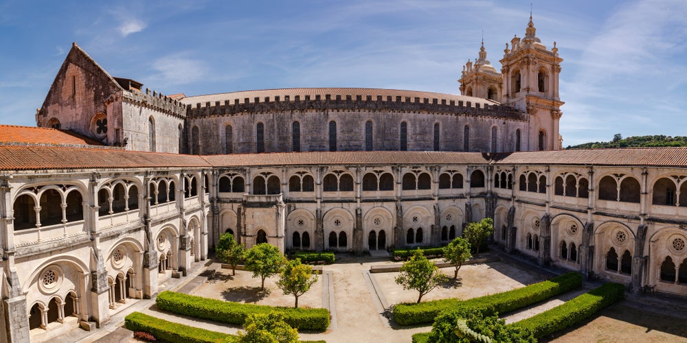 Photo of The church and the cross of the World Heritage Monastery of Saint Mary of Alcobaça, Portugal.