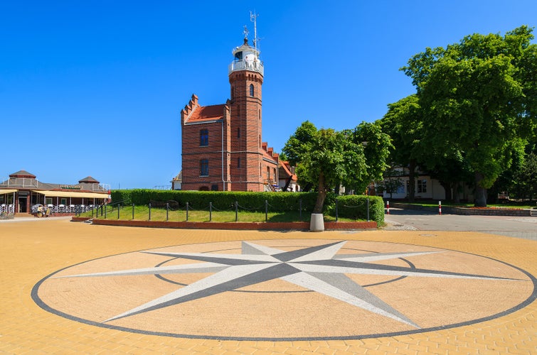 Brick lighthouse building compass rose square park, Ustka town, Baltic Sea, Poland