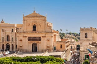 Photo of Italy Piazza Maggiore in Bologna old town tower of town hall with big clock and blue sky on background, antique buildings terracotta galleries.