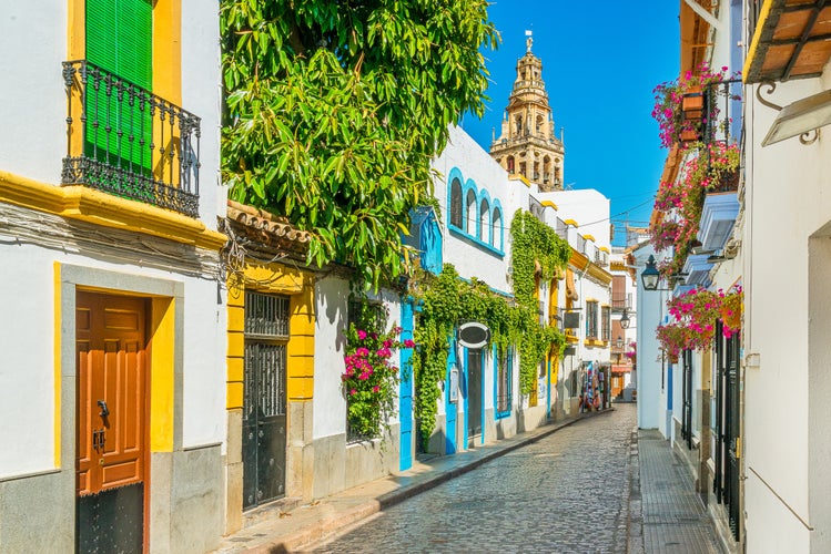 photo of view of Scenic sight in the picturesque Cordoba jewish quarter with the bell tower of the Mosque Cathedral. Andalusia, Spain.