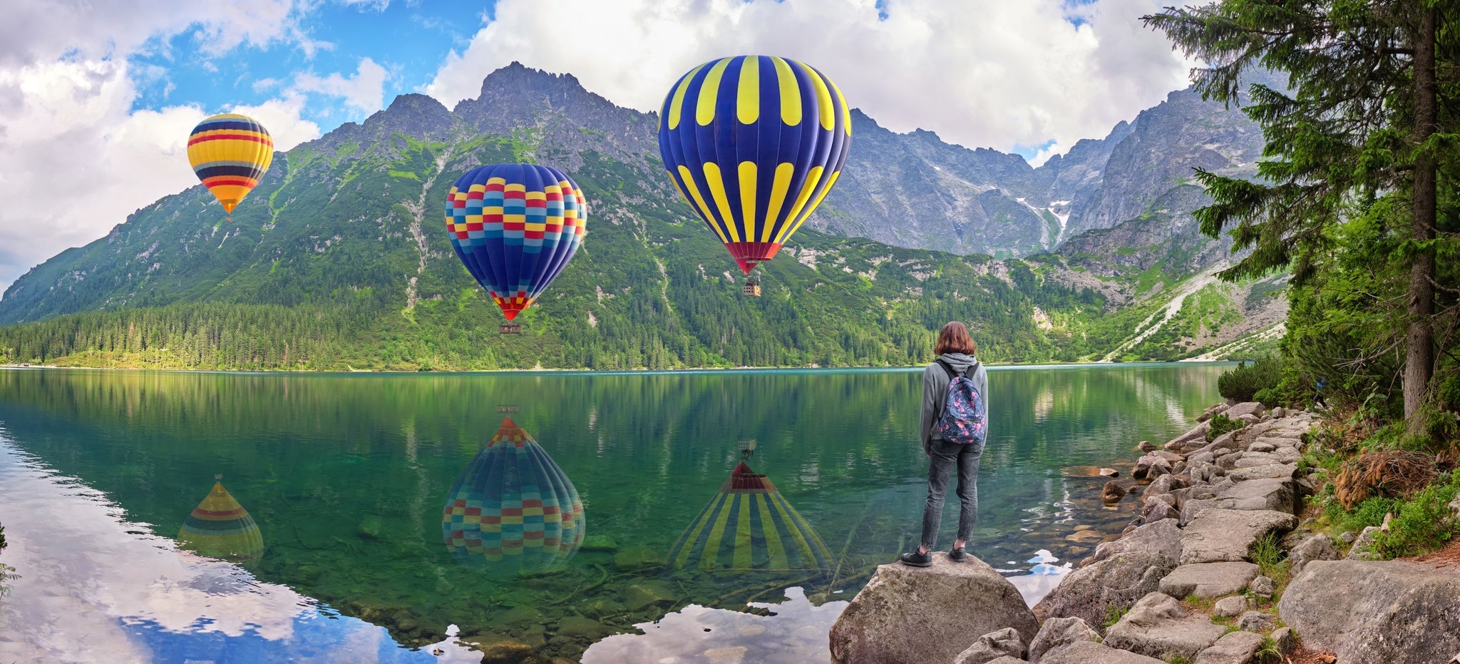 Young girl looks at hot air balloons over Morskoe Oko lake, Sea eye, Poland..jpg