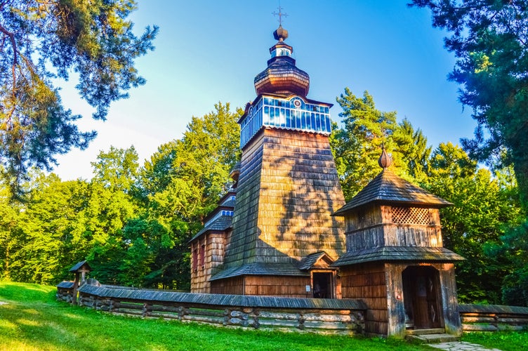 photo of view of Beautiful little wooden church in the forest of Sanok Skansen, Poland.