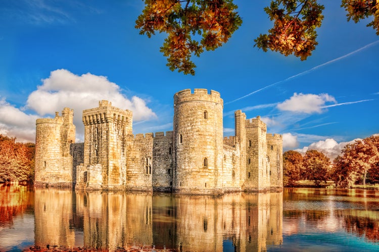 Photo of Historic Bodiam Castle with autumn leaves in East Sussex, England .