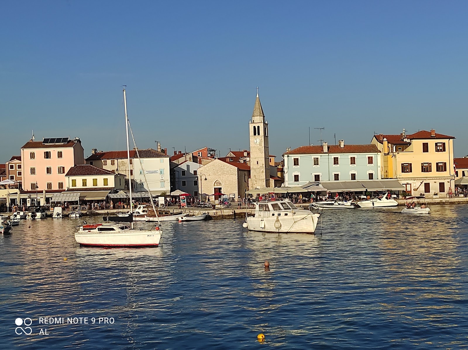 photo of an aerial view of the stunning Croatian coastal town of Pomer, with its picturesque oceanfront buildings and harbor.