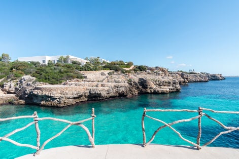 photo of the beautiful turquoise waters of Cala en Brut, Menorca beach, Balearic Islands, Spain.