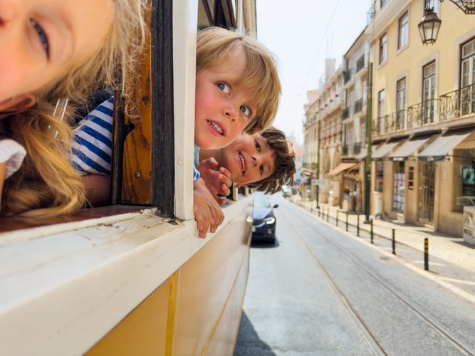 yellow tram in Libson with kids peeking out the window.jpg