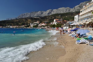 Photo of panorama and landscape of Makarska resort and its harbour with boats and blue sea water, Croatia.