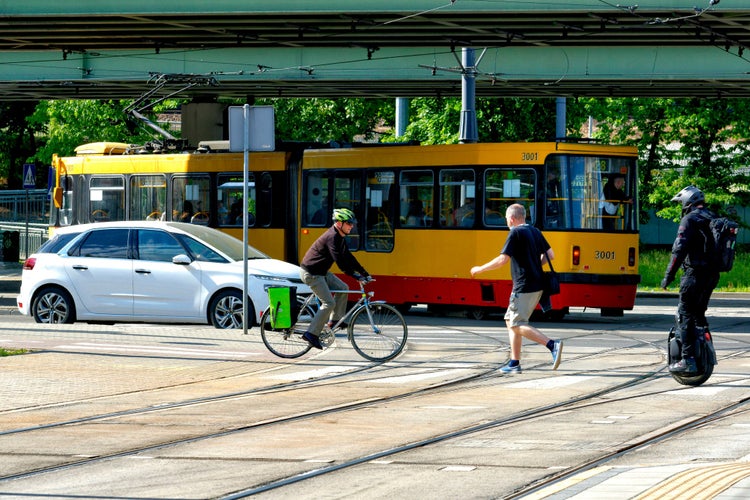 Poland, Warsaw, June 2021. Five different ways of getting around the city tram, car, on foot, bicycle, electric unicycle..jpg