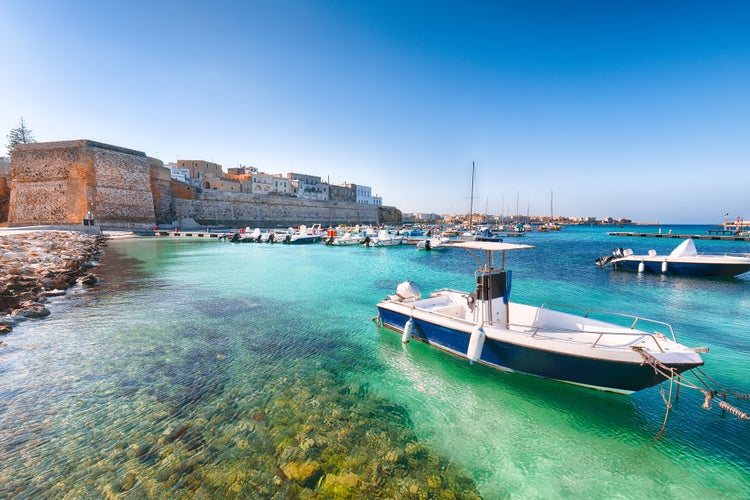 Several fishing boats at the Otranto harbour - coastal town in Puglia with turquoise sea. Italian vacation. Town Otranto, province of Lecce in the Salento peninsula, Puglia, Italy