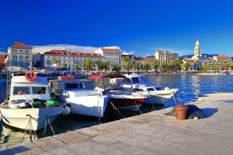 Photo of Adriatic sea coast with small boats tied to the pier in traditional town, Split, Croatia.