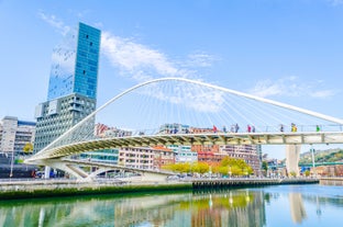 Photo of aerial view of Vizcaya bridge over the river and cityscape at Portugalete, Spain.