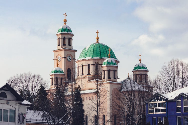 photo of view of Tuzla, Bosnia and Herzegovina. Main square in city centre. Minaret and mosque. Flag of Bosnia and Herzegovina.