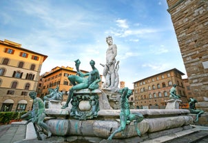 Photo of Italy Piazza Maggiore in Bologna old town tower of town hall with big clock and blue sky on background, antique buildings terracotta galleries.