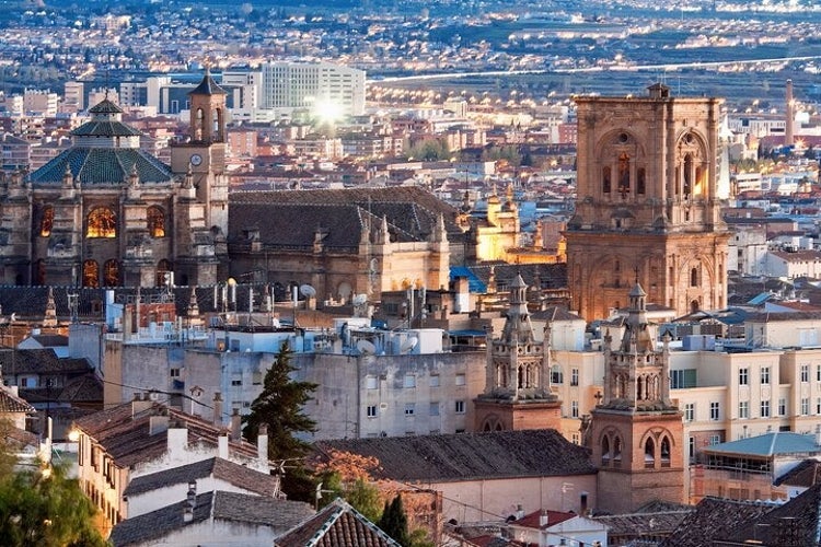 A view of the Royal Chapel of Granada and surrounding historic buildings at sunset, with modern structures in the background..jpg