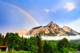 Photo of a view of the Alps from the Ehrwald, a town on the border of Germany and Austria with picturesque meadows surrounded by towering mountain ranges, including the Zugspitze.