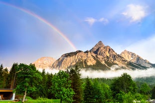 Photo of a view of the Alps from the Ehrwald, a town on the border of Germany and Austria with picturesque meadows surrounded by towering mountain ranges, including the Zugspitze.