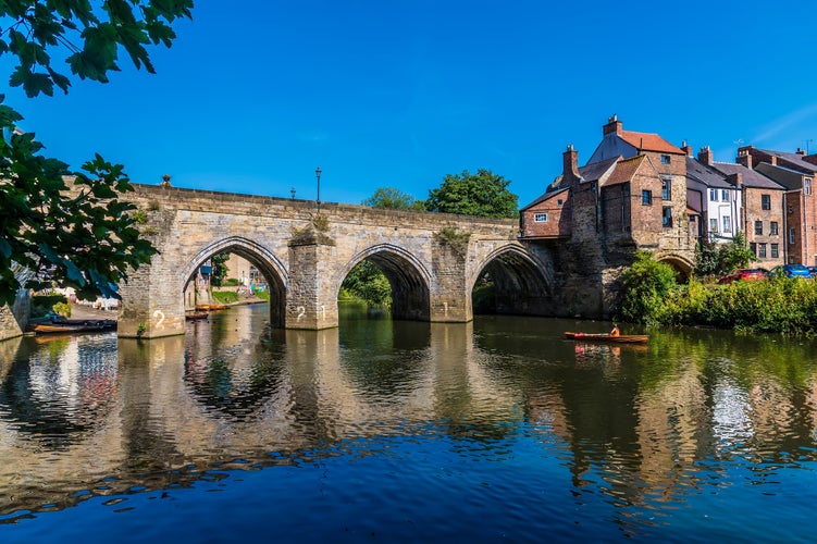 photo of view of A view through the tree lined shore towards the Elvet Bridge in Durham, UK in summertime.