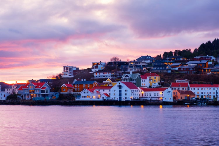 photo of view of Kristiansund, Norway. View of city center of Kristiansund, Norway during the cloudy morning at sunrise with colorful sky. Port with historical buildings