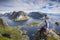 Lofoten, Norway. A view of Reine (Lofoten Island) from the top of Reinebringen. Young guy looking at the landscape.