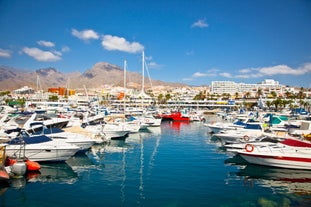 photo of aerial shot of Costa Adeje area, South Tenerife, Spain. Captured at golden hour, warm and vivid sunset colors. Luxury hotels, villas and restaurants behind the beach.