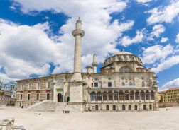 Touristic sightseeing ships in Golden Horn bay of Istanbul and mosque with Sultanahmet district against blue sky and clouds. Istanbul, Turkey during sunny summer day.