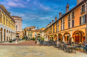 Photo of Old harbour Porto Vecchio with motor boats on turquoise water, green trees and traditional buildings in historical centre of Desenzano del Garda town, Northern Italy.