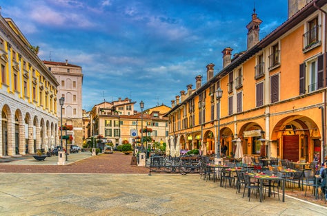 photo of view of Typical italian buildings and tables of street restaurants on Piazza del Mercato, Brescia, Italy.