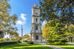 Touristic sightseeing ships in Golden Horn bay of Istanbul and mosque with Sultanahmet district against blue sky and clouds. Istanbul, Turkey during sunny summer day.