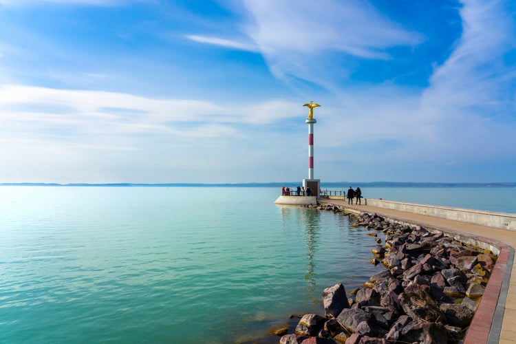 photo of view of pier in Siofok Hungary with a gold angel statue and walking path