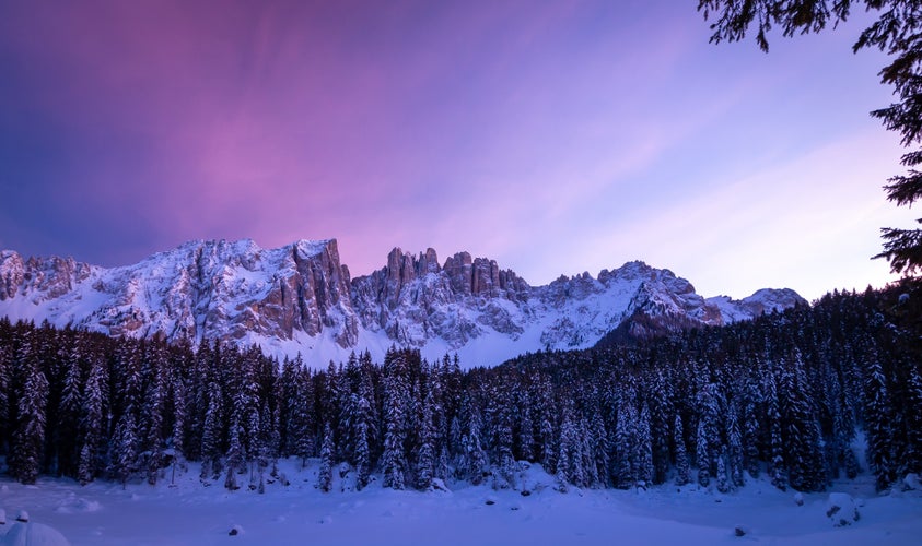 photo of view of Latemar mountain range reflected in Lake Carezza (Karersee) in winter , Karersee - Carezza, Italy.