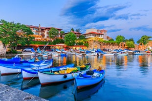 Photo of Saint Anastasia Island in Burgas bay, Black Sea, Bulgaria. Lighthouse tower and old wooden buildings on rocky coast.