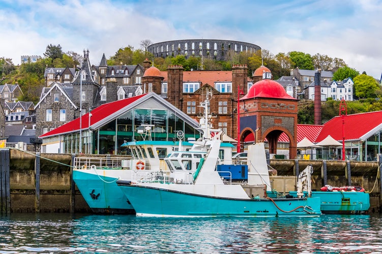 photo of view of A view of boats moored by the landing stage in the town of Oban, Scotland from Oban Bay on a summers day.