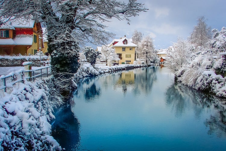 Photo of Interlaken idyllic landscape after snow in winter with river reflection, Swiss alps, Switzerland .