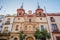 Photo of cityscape. architecture of church at hospital San Juan de Dios building on the Plaza del Salvador. Historical statues on the creamy colored wall. Sevilla, Andalusia. Spain.