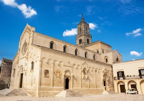 Photo of panoramic view of the ancient town of Matera (Sassi di Matera), European Capital of Culture 2019, in beautiful golden morning light with blue sky and clouds, Basilicata, southern Italy.